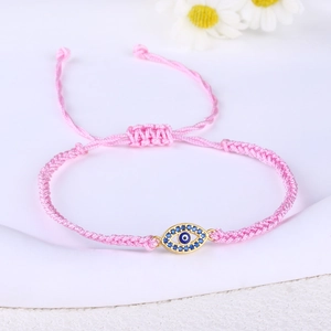 Detail of pink woven Evil Eye bracelet with gold-plated charm and blue zircon inlay