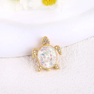 Macro detail of gold turtle pendant with vibrant opal shell and micro-pave zircons