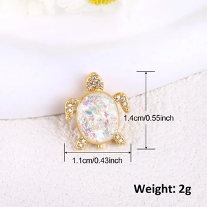 Macro shot of gold-plated turtle pendant with white opal and micro-pave crystals