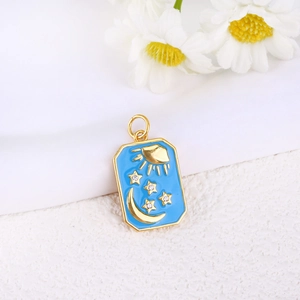 Detailed close-up of blue enamel celestial pendant with gold sun and moon motifs