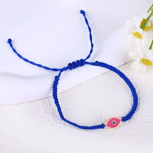 Close-up of a blue woven bracelet featuring a pink Evil Eye charm and adjustable pull knot