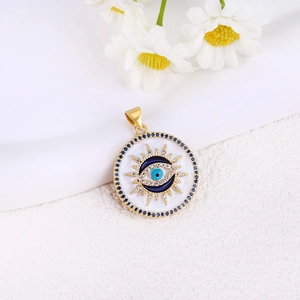 Detail of gold evil eye sun pendant with blue enamel and sparkling zircon accents