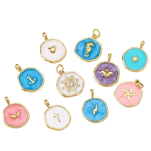 Macro shot of colorful enamel drips on gold-plated cross and heart charms for DIY jewelry