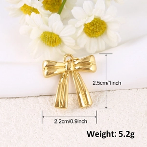 Détails de taille du pendentif nœud doré montrant la hauteur 2,5cm et largeur 2,2cm