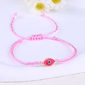 Detail of pink woven evil eye bracelet with adjustable cord and gold accents