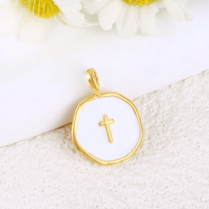 Macro shot of a gold-plated cross pendant with white enamel on textured fabric