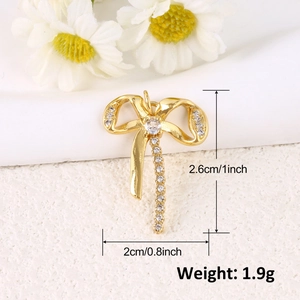 Vue détaillée d'un pendentif noeud doré avec zircons, dimensions 2,6 cm sur 2 cm