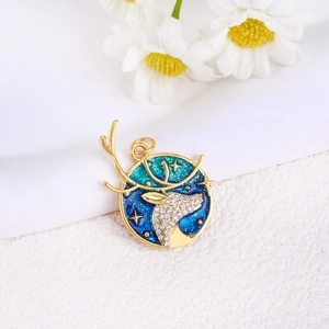 Detailed macro view of a gold-plated reindeer star planet pendant with blue enamel