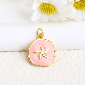 Detail of pink enamel heart pendant with golden floral charm for DIY jewelry making