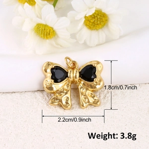 Détail d'un pendentif nœud doré de 2,2cm avec cœurs noirs et indications de taille