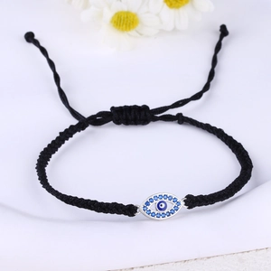 Detail of adjustable black woven bracelet with blue Evil Eye charm and tiny crystals
