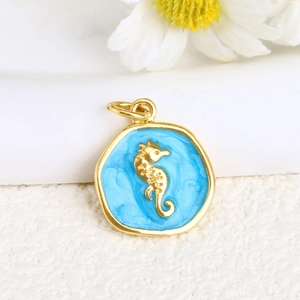 Macro detail of gold-plated seahorse pendant with light blue enamel and closed loop ring