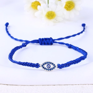 Macro view of blue braided cord bracelet with evil eye zircon pendant and adjustable knot