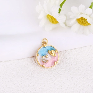 Macro detail of gold plated space pendant with blue enamel, stars and zircon moon charm