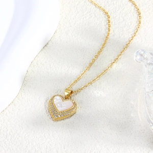 Elegante goldene Herzanhänger Halskette mit Perlmutt und Zirkonia auf weißem Stein
