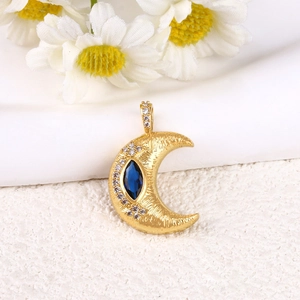 Dettaglio pendente a luna placcato oro con pietra blu marquise e finitura martellata