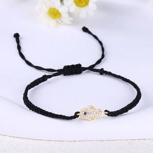 Detailed close-up of woven Hamsa Hand bracelet with sparkling Evil Eye charm