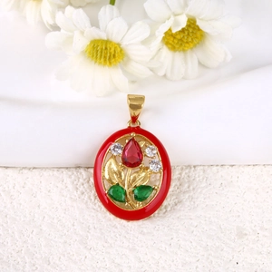 Detail of vintage oval floral pendant with red enamel, gold leaves, and ruby-red gemstone