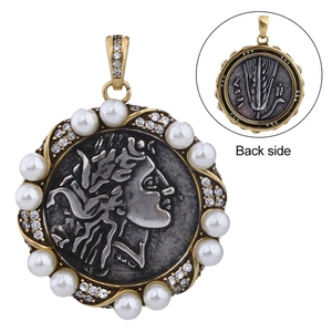 Macro view of vintage coin pendant with relief figure, pearls, and crystals showing back side