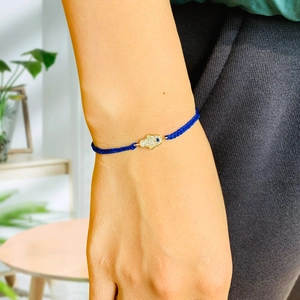 Detailed view of woven blue Hamsa Hand bracelet with crystal pavé and Evil Eye charm
