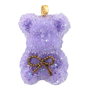 Vue détaillée d'un pendentif ours violet avec perles de résine et un nœud doré brillant