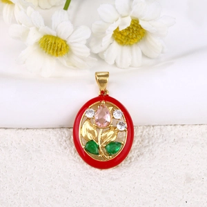 Macro detail of oval gold floral pendant with red enamel and multicolor gemstones