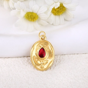 Detailed view of oval gold tulip pendant with red water-drop gemstone and relief pattern