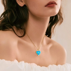 Detailansicht herzförmiger Opal-Anhänger mit Zirkonia-Halo an goldener Halskette