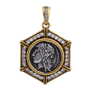 Detail of a gold hexagonal pendant with vintage goddess relief and zircon stones