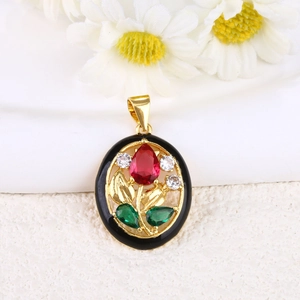 Macro shot of gold-plated tulip pendant with red and green gemstones and black enamel details