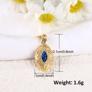 Dettaglio macro del ciondolo ovale placcato oro con zircone blu e trama a raggiera