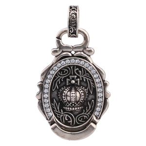 Macro detail of vintage silver coin pendant with crown relief and sparkling zirconia frame