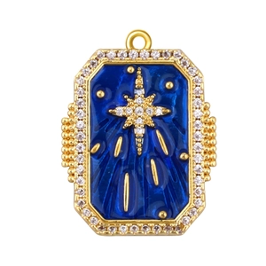 Macro view of blue enamel starburst charm with gold frame and cubic zirconia stones