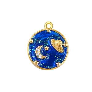 Detailed close-up of a gold-plated circular pendant with starry moon and saturn enamel motifs