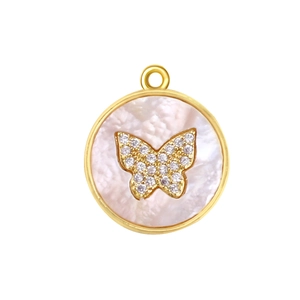 Close-up of a gold-plated circular pendant with white mother-of-pearl and crystal butterfly
