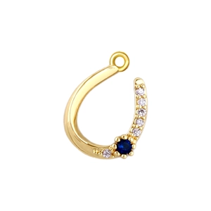 Macro view of horseshoe gold pendant with white zircon and a central blue sapphire stone