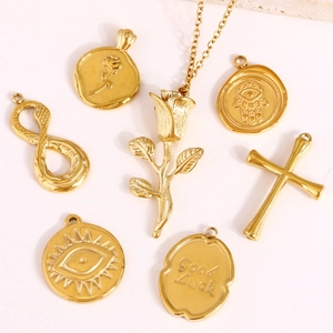 Pendentifs de collier en acier doré avec motifs de rose, croix et porte-bonheur sur fond blanc