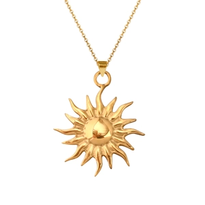 Detailed view of a polished gold celestial sunburst pendant on a fine link chain necklace