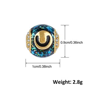 Vista dettagliata del charm verde smeraldo placcato oro con dimensioni di 0,9 cm per 1 cm