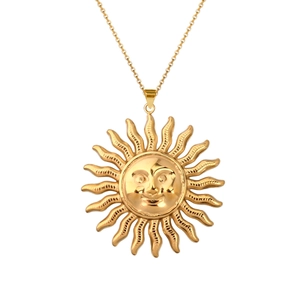 Detail shot of the golden sun god pendant with wave rays on a delicate link chain