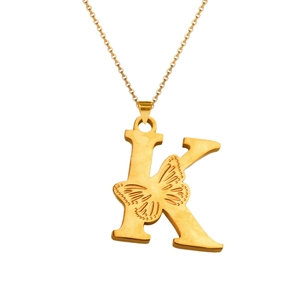 Macro detail of 18K gold stainless steel letter K pendant with engraved butterfly texture
