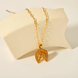 Dettaglio della collana ferro di cavallo in oro 18K con motivo testa di cavallo su catena