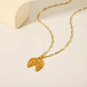 Dettaglio collana in acciaio inossidabile oro 18K con ciondolo ferro di cavallo e cavallo
