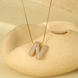 Detail of 18K gold plated balloon letter N pendant with pavé zircon stones on fine chain