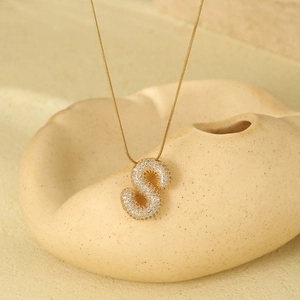 Detailed macro view of 18K gold-plated letter S pendant with shimmering zircon pavé