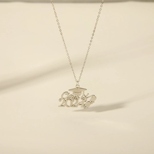 Detailopname van de Class of 2024 afstudeerpet en diploma hanger aan verfijnde ketting