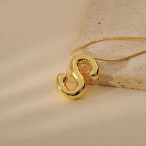 Detailed shot of a gold-plated bubble letter S pendant on a sleek snake chain necklace
