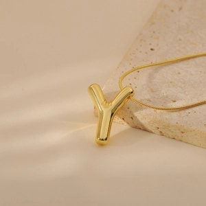 Detail shot of golden letter Y pendant with polished finish on a sleek snake chain