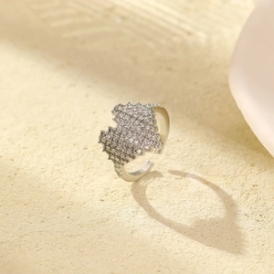 Funkelnder Ring mit Zirkonia-Herzbesatz und Versilberung auf strukturierter Steinfläche