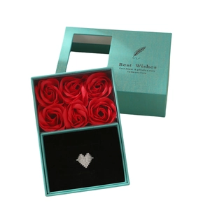 Türkise Geschenkbox mit sechs roten Rosen und einem Zirkonia-Herzring in offener Hülle